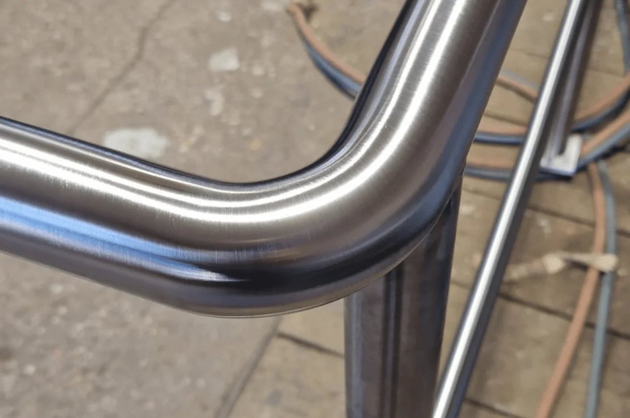 Na zdjęciu widać wysokiej jakości, wypolerowaną barierkę lub balustradę. Konstrukcja ta prezentuje się niezwykle estetycznie i solidnie. Metalowa balustrada została starannie wykończona i wypolerowana, co nadaje jej lśniący, gładki wygląd.