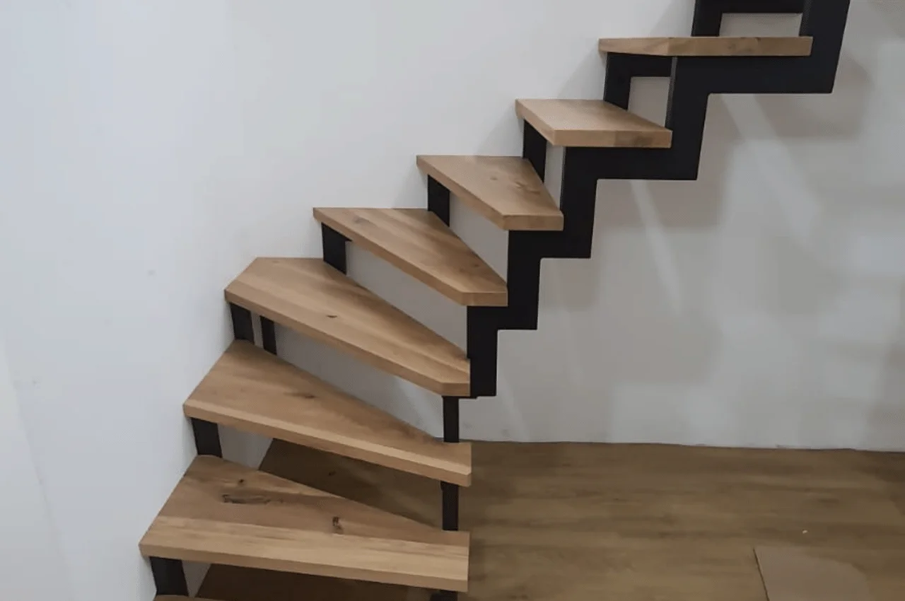 Na zdjęciu widać schody narożne. Schody te zostały zaprojektowane tak, aby pasować do kształtu narożnika budynku, co nadaje im funkcjonalny charakter.