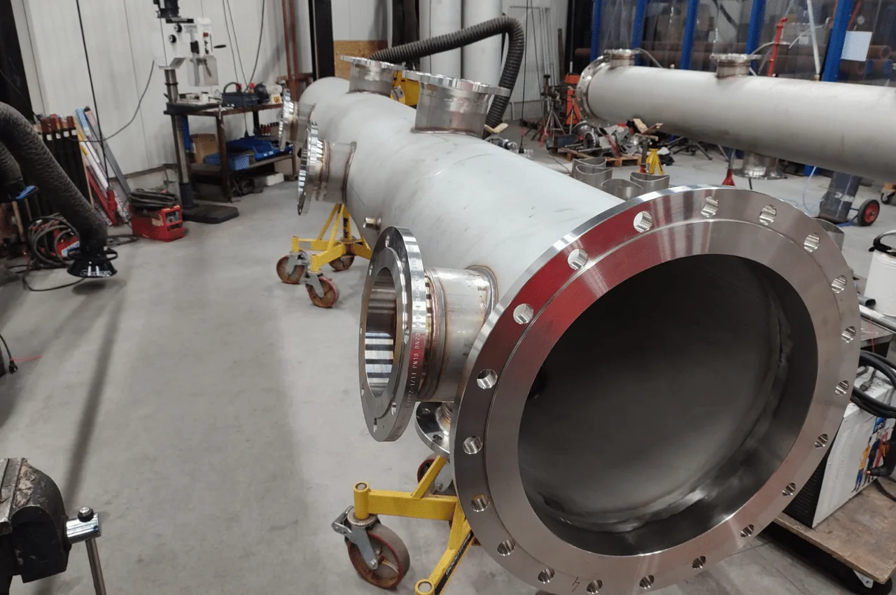 Na zdjęciu widać imponującą rurę o ogromnej średnicy, która służy do obsługi wyjątkowo wysokich ciśnień. Konstrukcja rury jest imponująco duża i solidna, co sugeruje, że jest ona przeznaczona do przewodzenia substancji lub płynów pod bardzo wysokim ciśnieniem