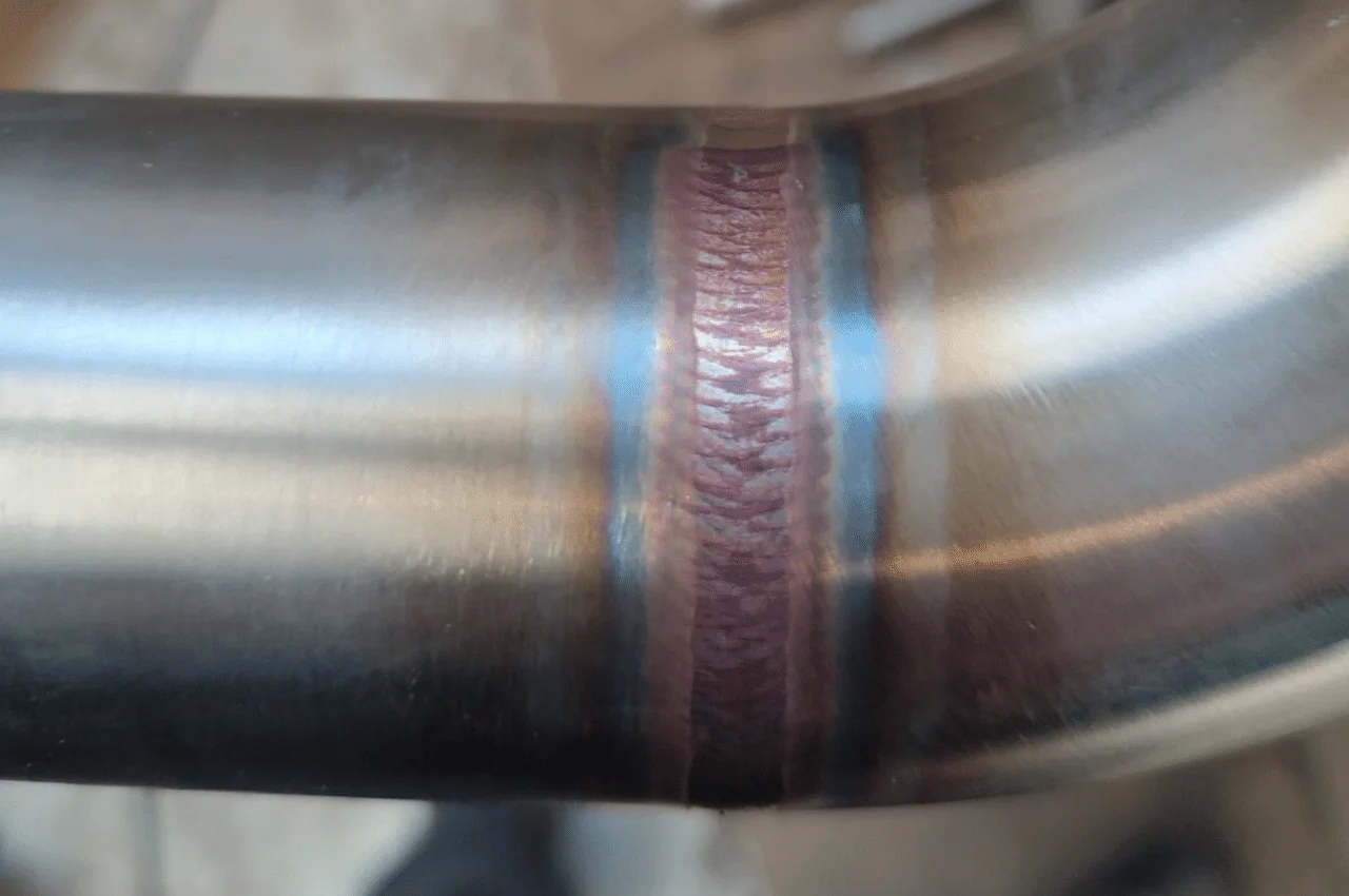 Na zdjęciu widać idealną spoinę, która perfekcyjnie połączyła dwie części rury. Spoina ta jest wykonana z ogromną precyzją i starannością, co świadczy o wysokim poziomie umiejętności spawacza.